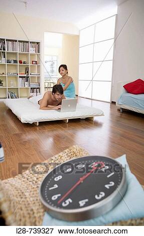Young couple in bedroom, woman massaging man, View Large Photo Image Stock Photo - Young couple in bedroom, woman massaging man,. Fotosearch