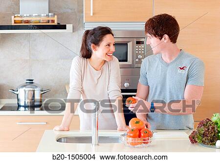 Picture - Young couple in kitchen. Fotosearch