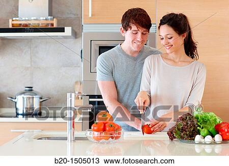 Stock Image - Young couple in kitchen. Fotosearch