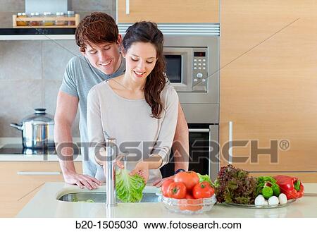 Stock Image - Young couple in kitchen. Fotosearch