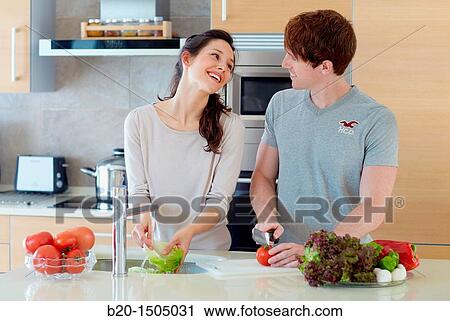 Stock Image - Young couple in kitchen. Fotosearch