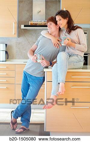 Stock Image - Young couple in kitchen. Fotosearch