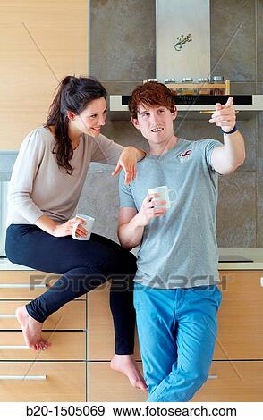 Young couple in kitchen View Large Photo Image Stock Photo - Young couple in kitchen. Fotosearch