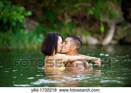 Stock Photo - Young couple in love - Asian woman, 20 years old, Korean Ethnicity, hispanic man, 22 years old, location Frio River near Leakey, Texas, USA. Fotosearch