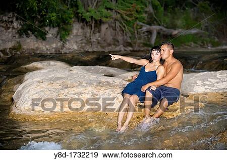 Stock Photo - Young couple in love - Asian woman, 20 years old, Korean Ethnicity, hispanic man, 22 years old, location Frio River near Leakey, Texas, USA. Fotosearch