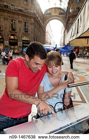 Young couple in Milan, looking at menu View Large Photo Image Stock Photo - Young couple in Milan, looking at menu. Fotosearch
