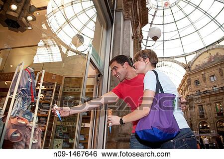 Young couple in Milan, looking at shop window View Large Photo Image Stock Photograph - Young couple in Milan, looking at shop window. Fotosearch