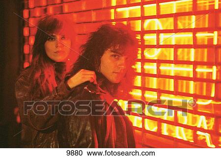 Young couple in the street with neon light View Large Photo Image Stock Image - Young couple in the street with neon light. Fotosearch