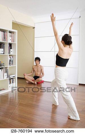 Young couple in yoga attitude, indoors View Large Photo Image Picture - Young couple in yoga attitude, indoors. Fotosearch