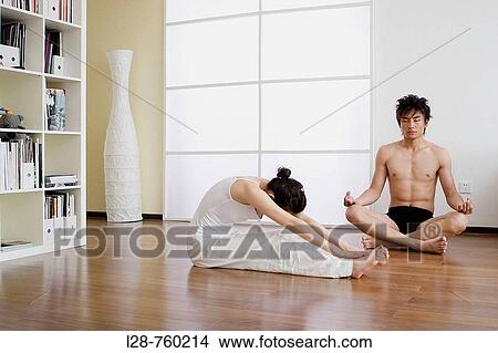 Picture - Young couple in yoga attitude, indoors. Fotosearch