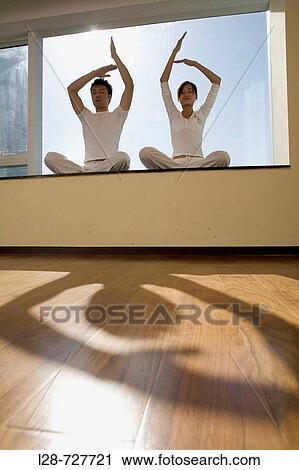 Young couple in yoga attitude indoors View Large Photo Image Stock Image - Young couple in yoga attitude indoors. Fotosearch