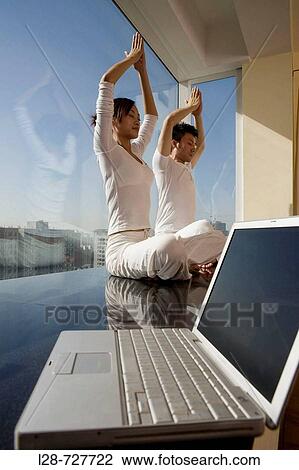 Young couple in yoga attitude indoors View Large Photo Image Stock Image - Young couple in yoga attitude indoors. Fotosearch