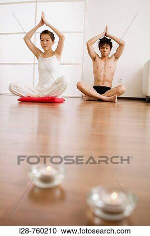 Young couple in yoga attitude, indoors View Large Photo Image Stock Image - Young couple in yoga attitude, indoors. Fotosearch