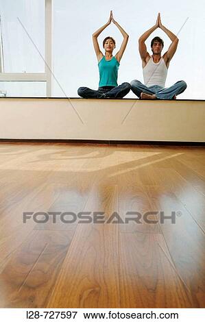 Young couple in yoga attitude indoors View Large Photo Image Stock Photo - Young couple in yoga attitude indoors. Fotosearch