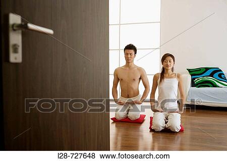 Young couple in yoga attitude, indoors View Large Photo Image Stock Photo - Young couple in yoga attitude, indoors. Fotosearch