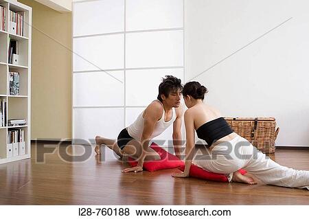 Young couple in yoga attitude, indoors View Large Photo Image Stock Photo - Young couple in yoga attitude, indoors. Fotosearch
