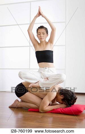 Young couple in yoga attitude, indoors View Large Photo Image Stock Photo - Young couple in yoga attitude, indoors. Fotosearch