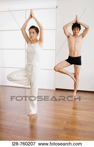 Stock Photo - Young couple in yoga attitude, indoors. Fotosearch