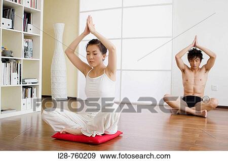 Young couple in yoga attitude, indoors View Large Photo Image Stock Photo - Young couple in yoga attitude, indoors. Fotosearch