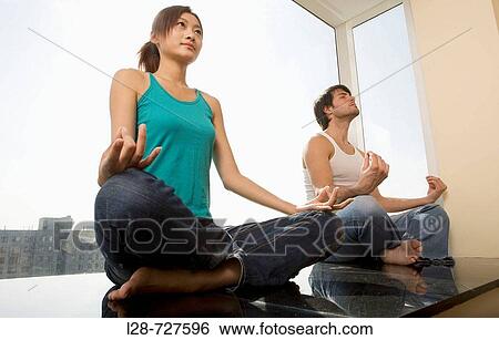 Young couple in yoga attitude, indoors View Large Photo Image Stock Photograph - Young couple in yoga attitude, indoors. Fotosearch