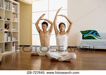 Young couple in yoga attitude, indoors View Large Photo Image Stock Photography - Young couple in yoga attitude, indoors. Fotosearch