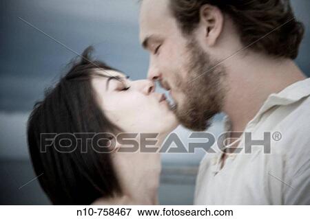 Young couple kissing by the ocean. View Large Photo Image Stock Photo - Young couple kissing by the ocean.. Fotosearch