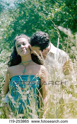 Young couple kissing in field View Large Photo Image Stock Photography - Young couple kissing in field. Fotosearch