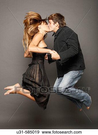 Stock Photo - Young couple kissing in the air.. Fotosearch