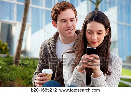 Young couple looking at mobile phone in the city, smartphone, Iberdrola Tower, Abandoibarra, Bilbao, Bizkaia, Basque Country, Spain View Large Photo Image Stock Image - Young couple looking at mobile phone in the city, smartphone, Iberdrola Tower, Abandoibarra, Bilbao, Bizkaia, Basque Country, Spain. Fotosearch