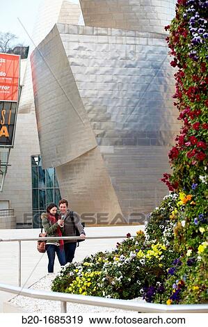 Young couple looking at mobile phone in the city, smartphone, Guggenheim Museum, Abandoibarra, Bilbao, Bizkaia, Basque Country, Spain View Large Photo Image Stock Photo - Young couple looking at mobile phone in the city, smartphone, Guggenheim Museum, Abandoibarra, Bilbao, Bizkaia, Basque Country, Spain. Fotosearch