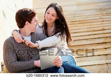 Young couple looking digital tablet in the city, digital tablet, Guggenheim Museum, Abandoibarra, Bilbao, Bizkaia, Basque Country, Spain View Large Photo Image Stock Image - Young couple looking digital tablet in the city, digital tablet, Guggenheim Museum, Abandoibarra, Bilbao, Bizkaia, Basque Country, Spain. Fotosearch