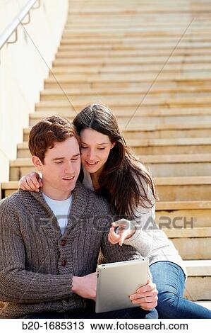 Young couple looking digital tablet in the city, digital tablet, Guggenheim Museum, Abandoibarra, Bilbao, Bizkaia, Basque Country, Spain View Large Photo Image Stock Image - Young couple looking digital tablet in the city, digital tablet, Guggenheim Museum, Abandoibarra, Bilbao, Bizkaia, Basque Country, Spain. Fotosearch