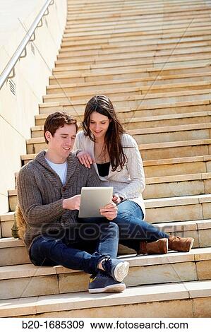 Young couple looking digital tablet in the city, digital tablet, Guggenheim Museum, Abandoibarra, Bilbao, Bizkaia, Basque Country, Spain View Large Photo Image Stock Photo - Young couple looking digital tablet in the city, digital tablet, Guggenheim Museum, Abandoibarra, Bilbao, Bizkaia, Basque Country, Spain. Fotosearch
