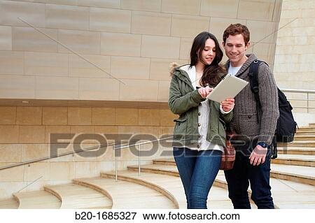 Young couple looking digital tablet in the city, digital tablet, Guggenheim Museum, Abandoibarra, Bilbao, Bizkaia, Basque Country, Spain View Large Photo Image Stock Photo - Young couple looking digital tablet in the city, digital tablet, Guggenheim Museum, Abandoibarra, Bilbao, Bizkaia, Basque Country, Spain. Fotosearch