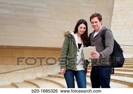 Young couple looking digital tablet in the city, digital tablet, Guggenheim Museum, Abandoibarra, Bilbao, Bizkaia, Basque Country, Spain View Large Photo Image Stock Photograph - Young couple looking digital tablet in the city, digital tablet, Guggenheim Museum, Abandoibarra, Bilbao, Bizkaia, Basque Country, Spain. Fotosearch
