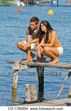 Young couple on a wooden pier View Large Photo Image Picture - Young couple on a wooden pier. Fotosearch