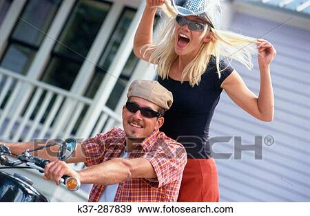 Young couple on motor cycle in urban setting View Large Photo Image Stock Photo - Young couple on motor cycle in urban setting. Fotosearch