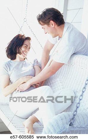 Young couple on porch swing in spring-summer, playfully tickling and laughing with each other View Large Photo Image Stock Photography - Young couple on porch swing in spring-summer, playfully tickling and laughing with each other. Fotosearch