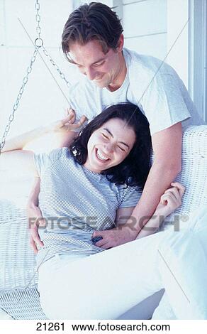 Young couple on porch swing, laughing as they tickle each other View Large Photo Image Stock Image - Young couple on porch swing, laughing as they tickle each other. Fotosearch