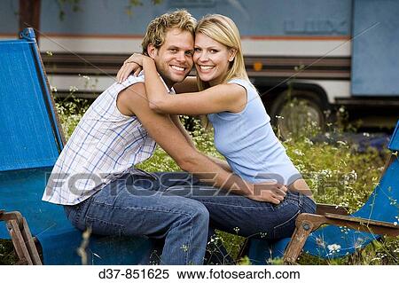 Young couple oudoors looking at camera View Large Photo Image Stock Photography - Young couple oudoors looking at camera. Fotosearch