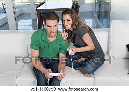 Stock Image - Young couple playing video games. Fotosearch