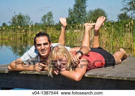 Young couple relaxing at a lake, Germany, Europe View Large Photo Image Picture - Young couple relaxing at a lake, Germany, Europe. Fotosearch