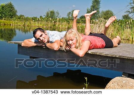 Stock Image - Young couple relaxing at a lake, Germany, Europe. Fotosearch