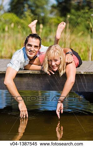 Young couple relaxing at a lake, Germany, Europe View Large Photo Image Stock Photography - Young couple relaxing at a lake, Germany, Europe. Fotosearch