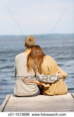 Young couple relaxing, sitting in a Pier in Wansee, Berlin View Large Photo Image Stock Photograph - Young couple relaxing, sitting in a Pier in Wansee, Berlin. Fotosearch