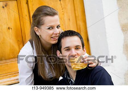 Young couple, she is feeding him View Large Photo Image Stock Photography - Young couple, she is feeding him. Fotosearch