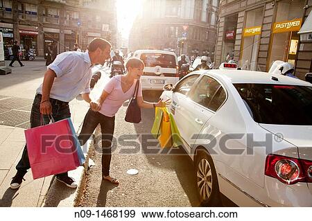 Young couple shopping in Milan, taking taxi View Large Photo Image Stock Photo - Young couple shopping in Milan, taking taxi. Fotosearch