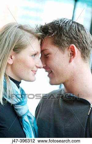 Young couple, sitting facing each other, noses together, smiling View Large Photo Image Stock Image - Young couple, sitting facing each other, noses together, smiling. Fotosearch