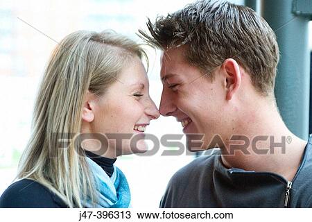 Young couple, sitting facing each other, noses together, smiling View Large Photo Image Stock Image - Young couple, sitting facing each other, noses together, smiling. Fotosearch