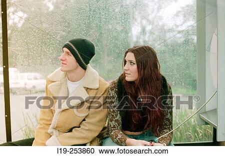 Young couple sitting in bus stop in rain View Large Photo Image Stock Image - Young couple sitting in bus stop in rain. Fotosearch